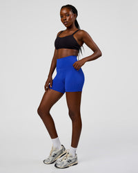 Woman wearing Fusion V-Contour Ultra High-Rise 4” Short Pockets - Electric Indigo | Model:Ellie | Size:S | Thumbnail Index: 4