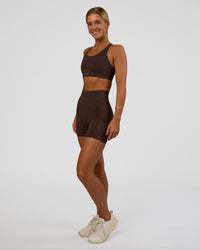 Woman wearing Fusion V-Contour Ultra High-Rise 4” Short Pockets - Hot Chocolate | Model:Amity | Size:S | Thumbnail Index: 2