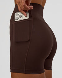 Woman wearing Fusion V-Contour Ultra High-Rise 4” Short Pockets - Hot Chocolate | Model:Amity | Size:S | Thumbnail Index: 3