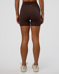 Woman wearing Fusion V-Contour Ultra High-Rise 4” Short Pockets - Hot Chocolate | Model:Amity | Size:S | Thumbnail Index: 1