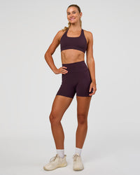 Woman wearing Fusion V-Contour Ultra High-Rise 4” Short Pockets - Midnight Plum | Model:Emelia | Size:S | Thumbnail Index: 3