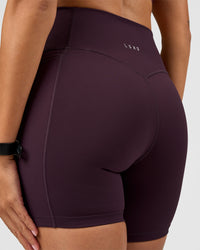 Woman wearing Fusion V-Contour Ultra High-Rise 6" Short Pockets - Midnight Plum | Model:Rhiley | Size:S | Thumbnail Index: 0