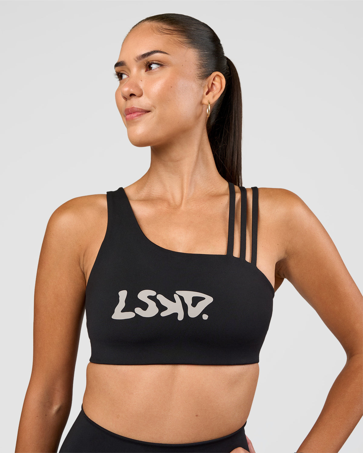 Woman wearing Galvanise Hype Graphic Sports Bra 2.0 - Black-Alloy | Model:Rhiley | Size:S