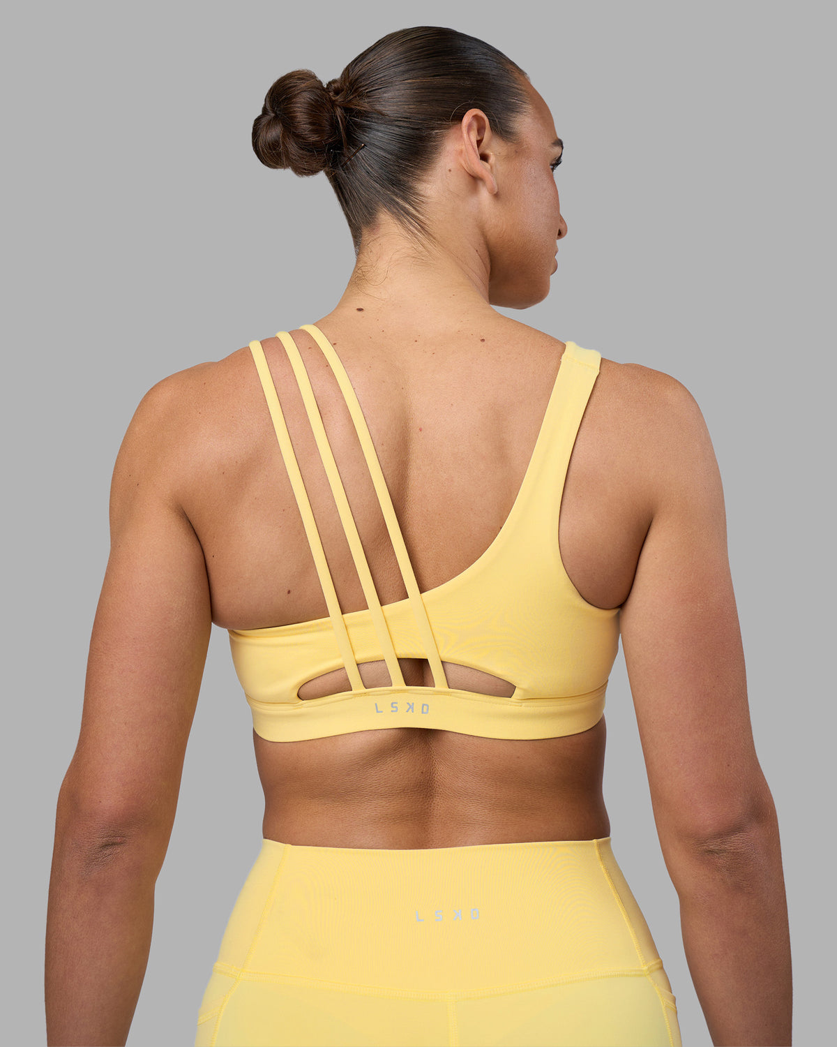 Woman wearing Galvanise Sports Bra 2.0 - Lemon | Set:true | Angle:back | Model:Sophie | Size:S