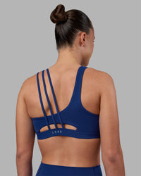 Woman wearing Galvanise Sports Bra 2.0 - Midnight Blue | Set:true | Angle:back | Model:Charlize | Size:S | Thumbnail Index: 1
