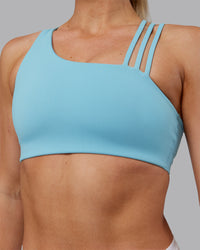 Woman wearing Galvanise Sports Bra 2.0 - Retro Blue | Set:true | Angle:closeup | Model:Hannah | Size:S | Thumbnail Index: 3