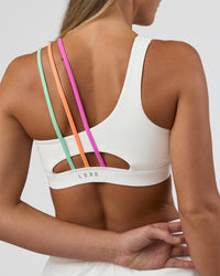 Woman wearing Galvanise Sports Bra 2.0 - Off White-Multi | Set:true | Angle:back | Model:Amity | Size:S | Thumbnail Index: 1