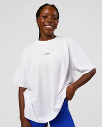 Woman wearing Go-To Run Club FLXCotton Oversized Tee - White-Electric Indigo | Model:Ellie | Size:S | Thumbnail Index: 1