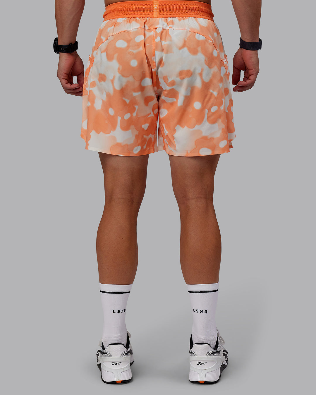 Man wearing Grand Slam 6" Shorts in Wildflower Cantaloupe | Size:S - view 12
