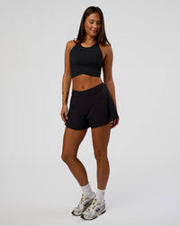 Woman wearing Hybrid Performance Crossover Tank - Black | Model:Bianca | Size:S | Thumbnail Index: 1