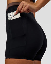 Woman wearing Liberate High-Rise 4" Short Pockets in Black-Cocoa Powder | Model:Bianca | Size:S | Thumbnail Index: 1