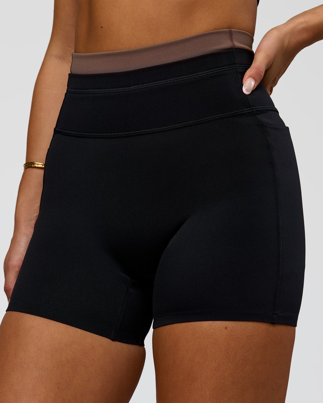 Woman wearing Liberate High-Rise 4" Short Pockets in Black-Cocoa Powder | Model:Bianca | Size:S - view 1