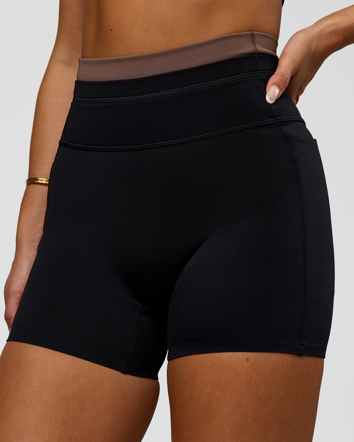 Woman wearing Liberate High-Rise 4" Short Pockets in Black-Cocoa Powder | Model:Bianca | Size:S