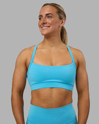 Woman wearing Momentum Sports Bra - Blue Atoll | Model:Georgia | Size:S | Thumbnail Index: 1