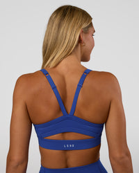 Woman wearing Momentum Sports Bra - Electric Indigo | Model:Amity | Size:S | Thumbnail Index: 1
