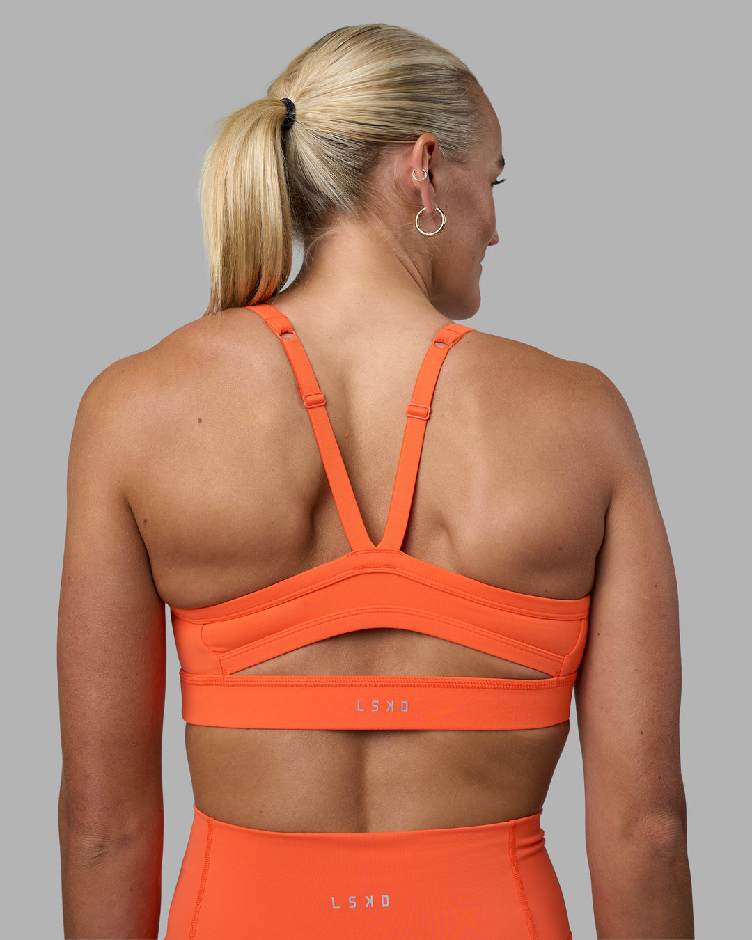 Woman wearing Momentum Sports Bra - Ultra Orange | Model:Katie | Size:S - view 2