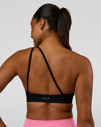 Woman wearing Muse Asymmetric Sports bra - Black | Model:Rosie | Size:S | Thumbnail Index: 1