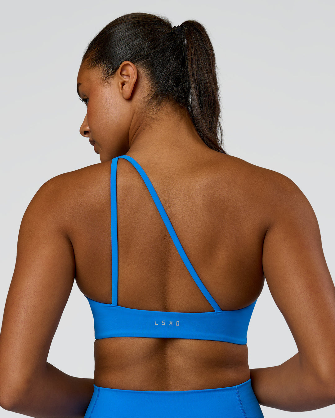 Woman wearing Muse Asymmetric Sports bra - Palace Blue | Model:Rosie | Size:S - view 7