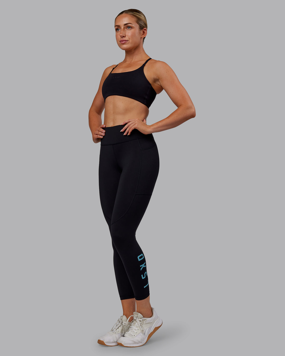 Woman wearing Rep Ultra High-Rise 7/8 Legging Pockets - Black-Retro Blue | Model:Paris | Size:S