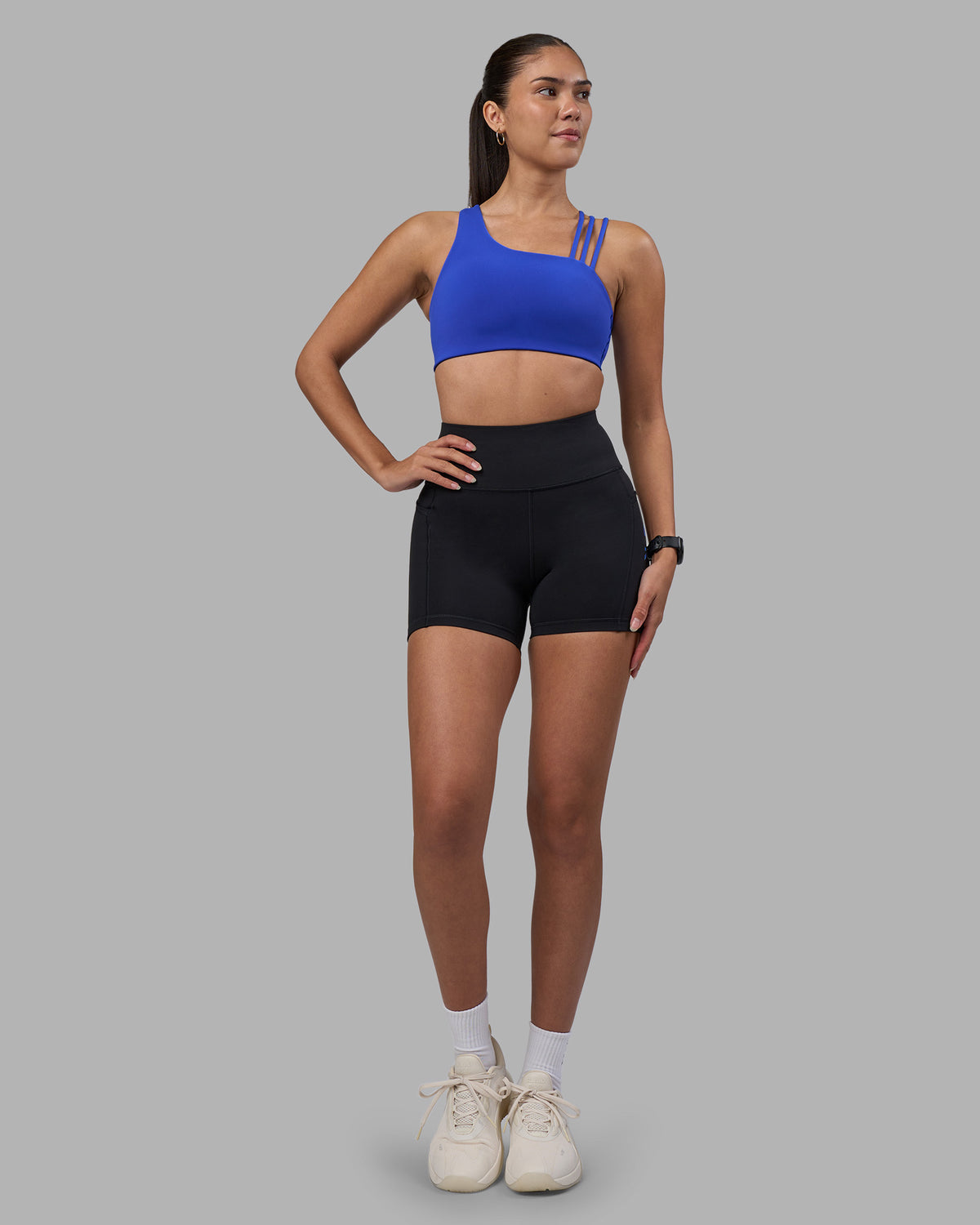 Woman wearing Rep Ultra High-Rise 4" Short Pockets - Black-Power Cobalt | Model:Rhiley | Size:S