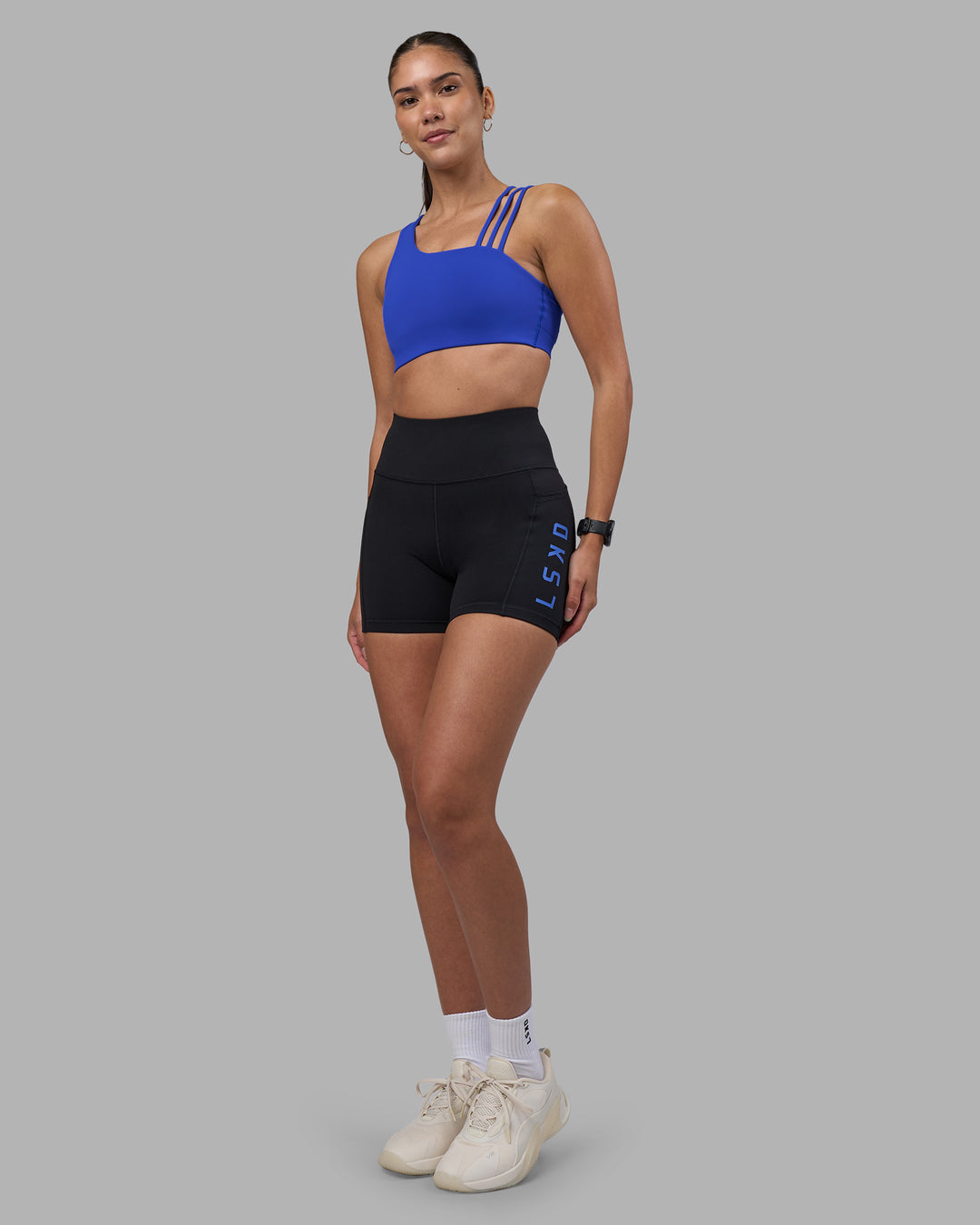 Woman wearing Rep Ultra High-Rise 4" Short Pockets - Black-Power Cobalt | Model:Rhiley | Size:S - view 5