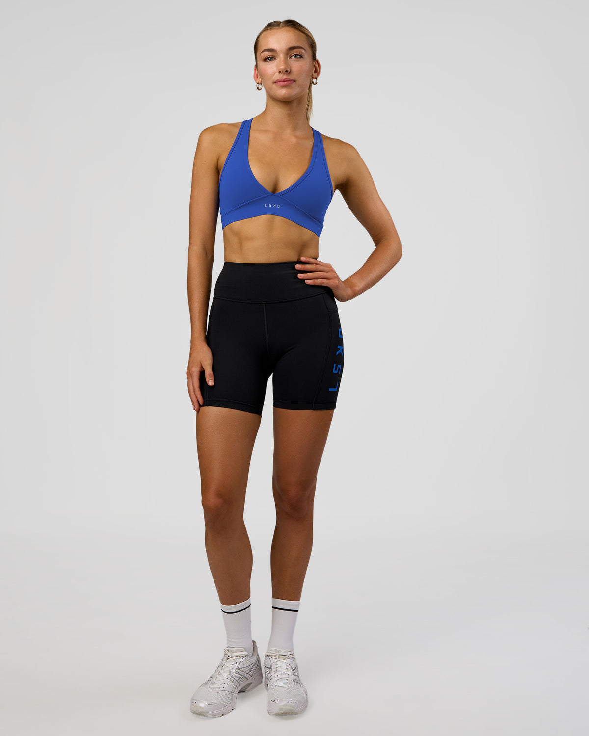 Woman wearing Rep Ultra High-Rise 6" Short Pockets - Black-Electric Indigo | Model:Evie | Size:S