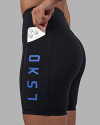 Woman wearing Rep Ultra High-Rise 6" Short Pockets - Black-Power Cobalt | Model:Rhiley | Size:S | Thumbnail Index: 0