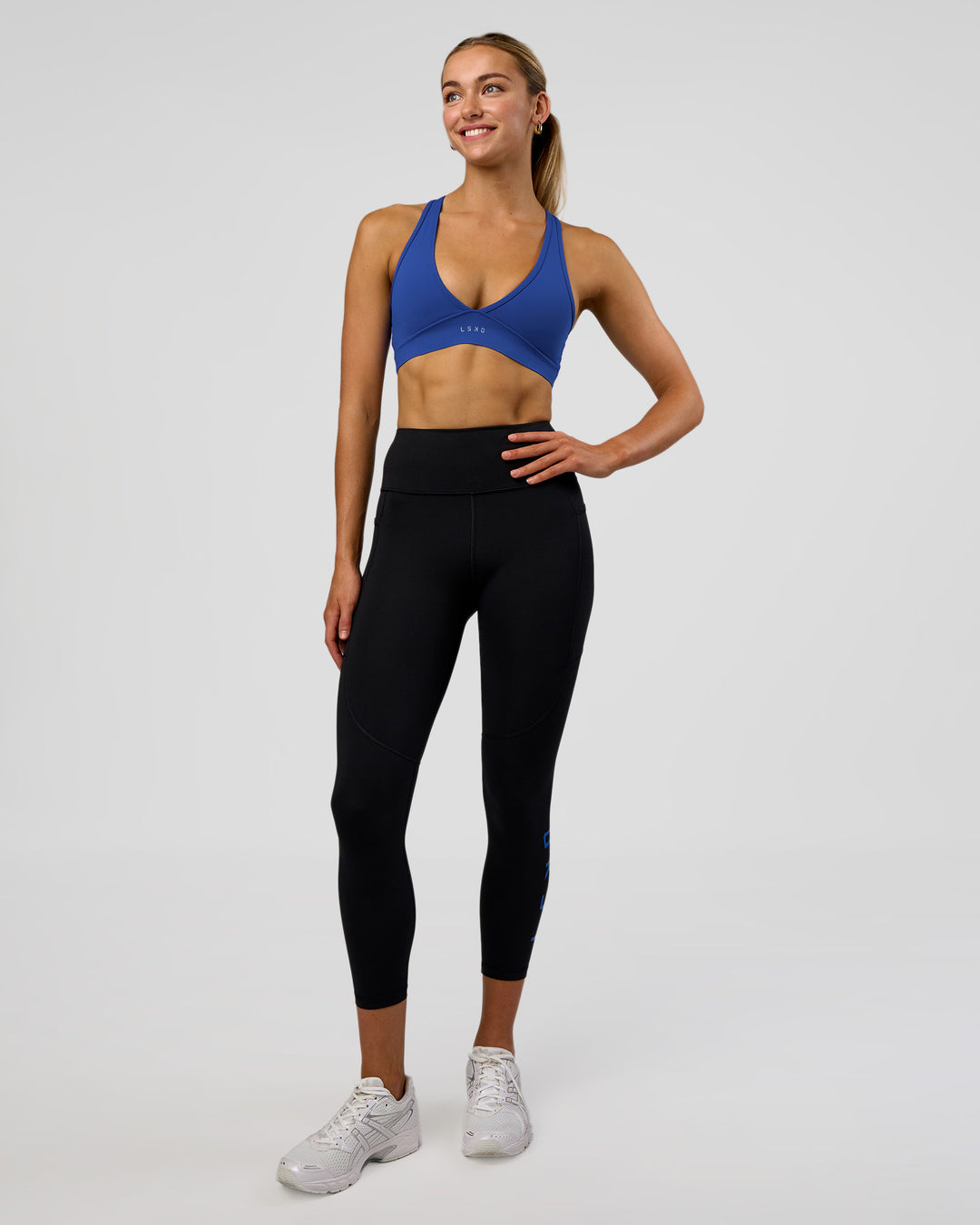 Woman wearing Rep Ultra High-Rise 7/8 Legging Pockets - Black-Electric Indigo | Model:Evie | Size:S - view 2