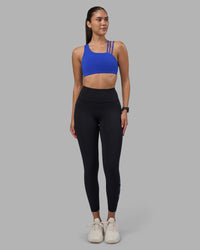 Woman wearing Rep Ultra High-Rise 7/8 Legging Pockets - Black-Power Cobalt | Model:Rhiley | Size:S | Thumbnail Index: 1