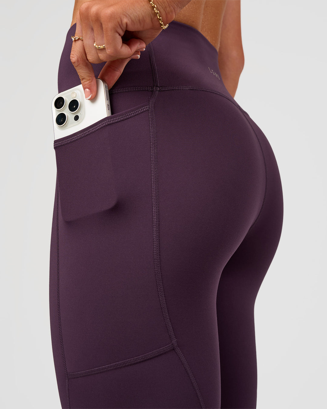 Woman wearing Rep Ultra High-Rise 7/8 Legging Pockets - Midnight Plum-Marshmallow | Model:Emelia | Size:S - view 3