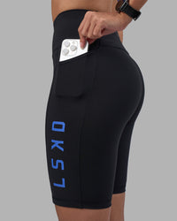 Woman wearing Rep Ultra High-Rise 9" Short Pockets - Black-Power Cobalt | Model:Rhiley | Size:S | Thumbnail Index: 2