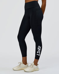 Woman wearing Rep Street Script Ultra High-Rise 7/8 Legging Pockets - Black-White | Model:Rosie | Size:S | Thumbnail Index: 1