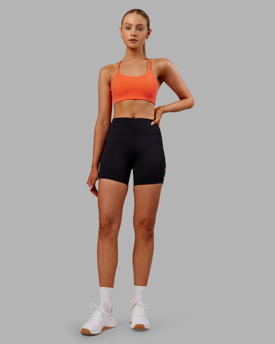 Woman wearing Rep Ultra High-Rise 4" Short Pockets - Black-Ultra Orange | Model:Ella | Size:S - view 3