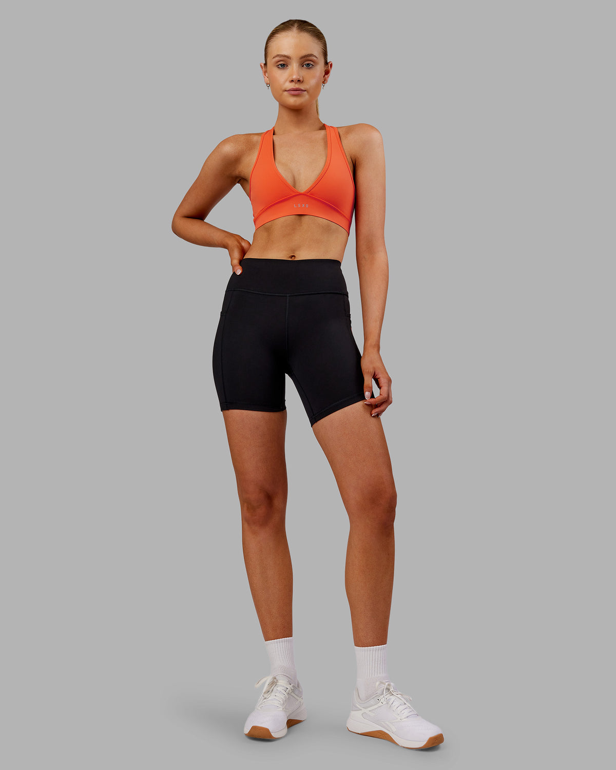 Woman wearing Rep Ultra High-Rise 6" Short Pockets - Black-Ultra Orange | Model:Ella | Size:S