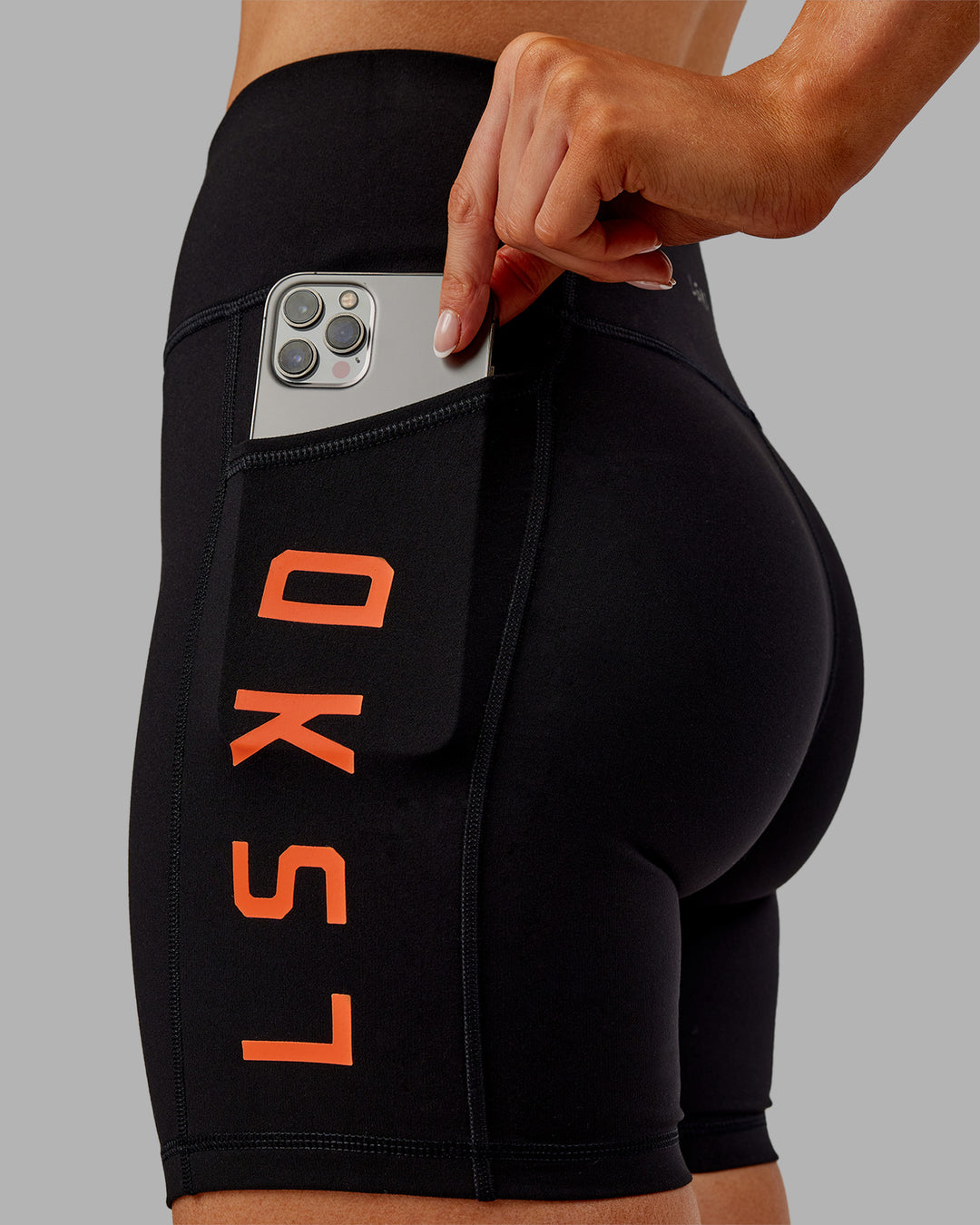 Woman wearing Rep Ultra High-Rise 6" Short Pockets - Black-Ultra Orange | Model:Ella | Size:S - view 1
