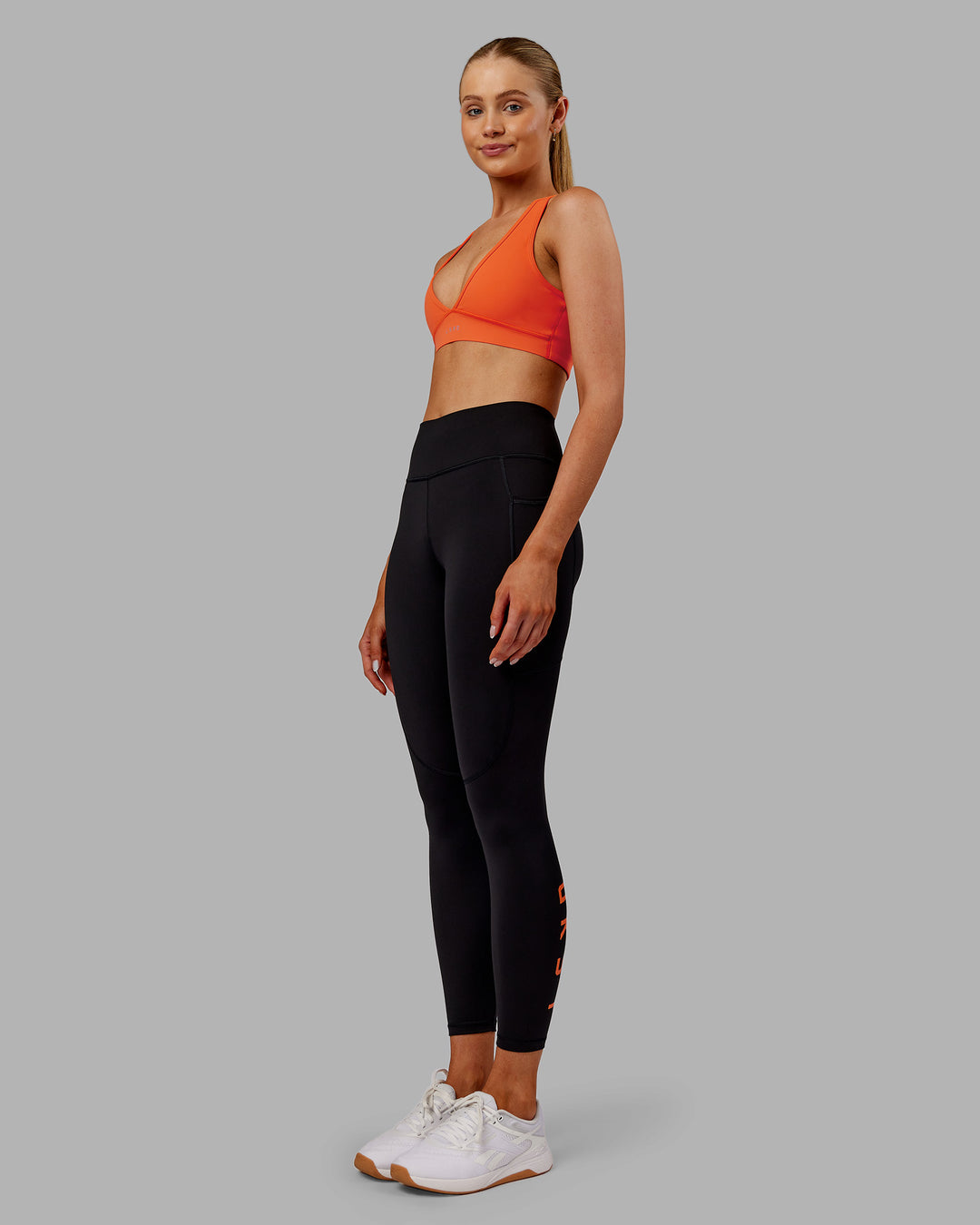 Woman wearing Rep Ultra High-Rise 7/8 Legging Pockets - Black-Ultra Orange | Model:Ella | Size:S - view 5