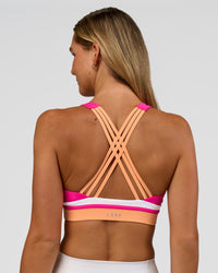 Woman wearing Revitalise Flash Sports Bra - Ultra Pink-Cantaloupe-White | Model:Amity | Size:S | Thumbnail Index: 0