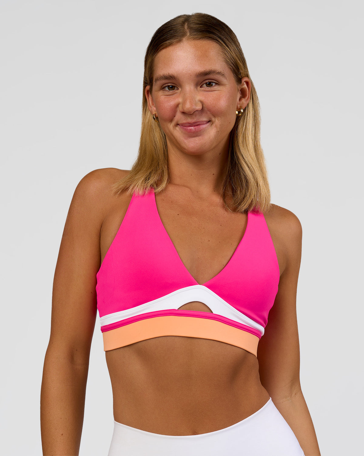 Woman wearing Revitalise Flash Sports Bra - Ultra Pink-Cantaloupe-White | Model:Amity | Size:S