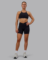 Woman wearing Sara Strike Ultra High-Rise Cross Over Waist 6" Short - Black | Thumbnail Index: 1