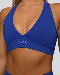Woman wearing Stamina Sports Bra - Electric Indigo | Set:true | Angle:closeup | Model:Amity | Size:S | Thumbnail Index: 3
