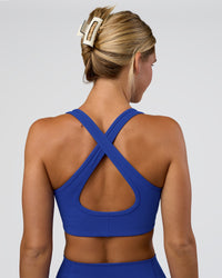 Woman wearing Stamina Sports Bra - Electric Indigo | Set:true | Angle:back | Model:Amity | Size:S | Thumbnail Index: 5