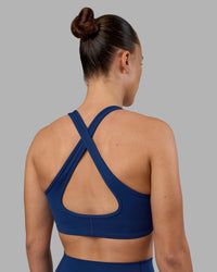 Woman wearing Stamina Sports Bra - Midnight Blue | Set:true | Angle:back | Model:Charlize | Size:S | Thumbnail Index: 1