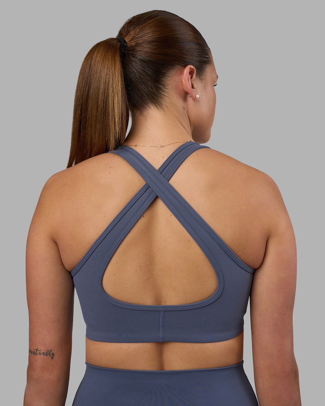 Woman wearing Stamina Sports Bra - Night Shadow | Set:true | Angle:back | Model:Phoebe | Size:S - view 2