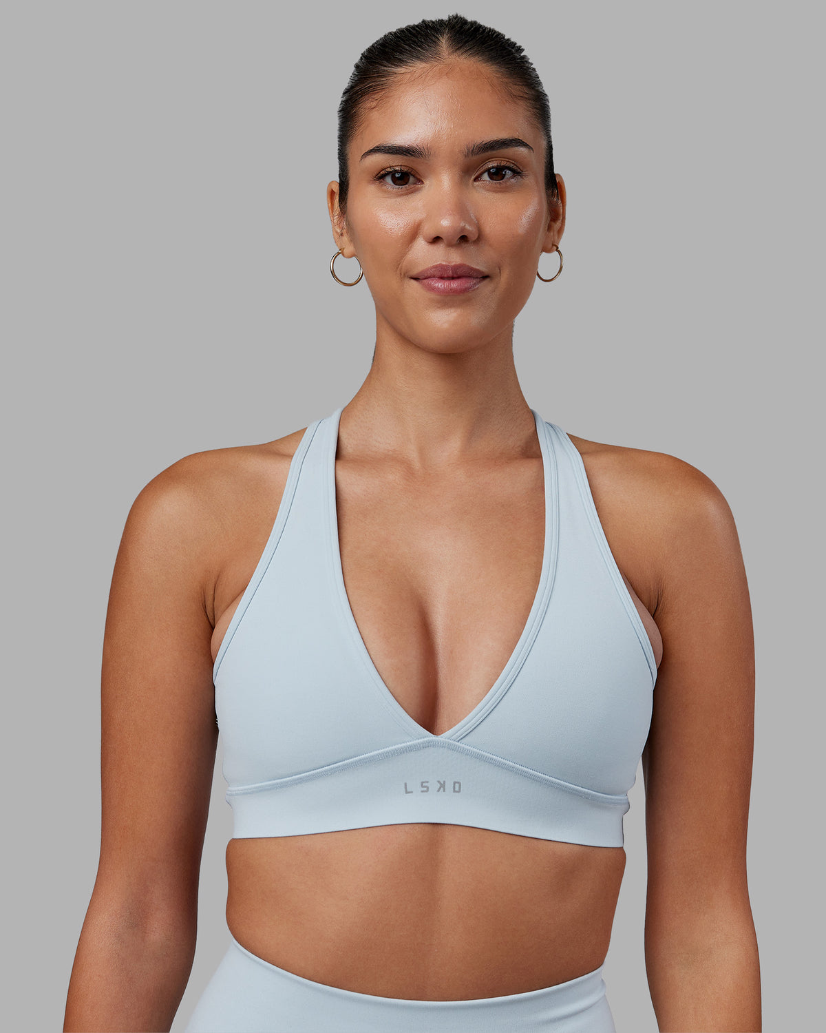 Woman wearing Stamina Sports Bra - Skyride | Set:true | Angle:front | Model:Rhiley | Size:S