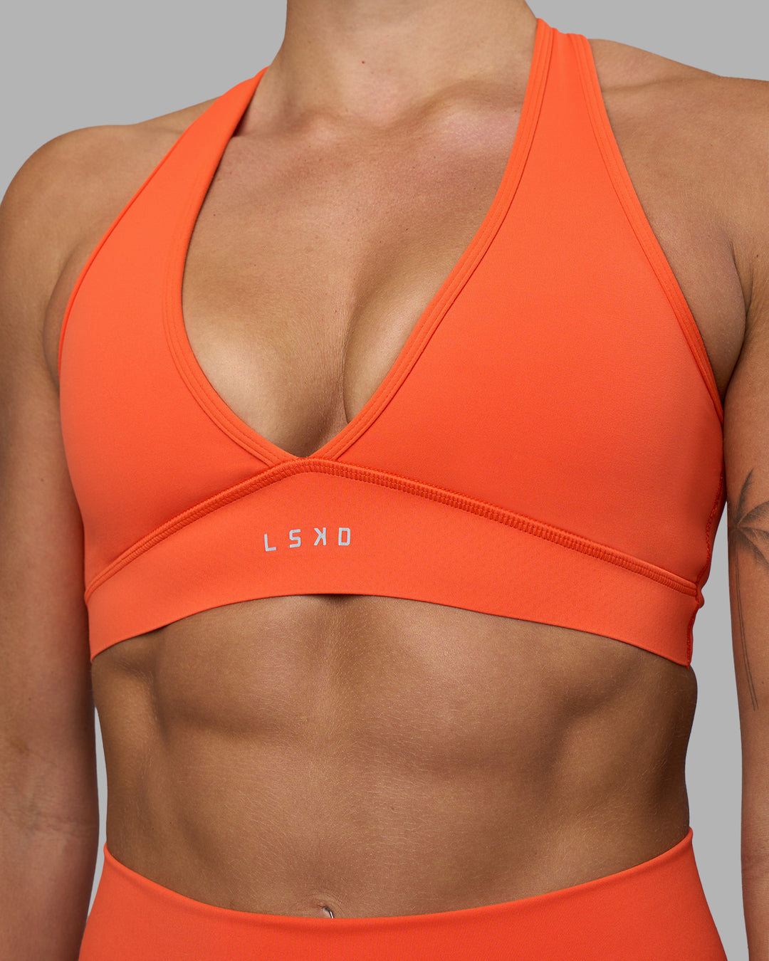 Woman wearing Stamina Sports Bra - Ultra Orange | Set:true | Angle:closeup | Model:Katie | Size:S - view 4