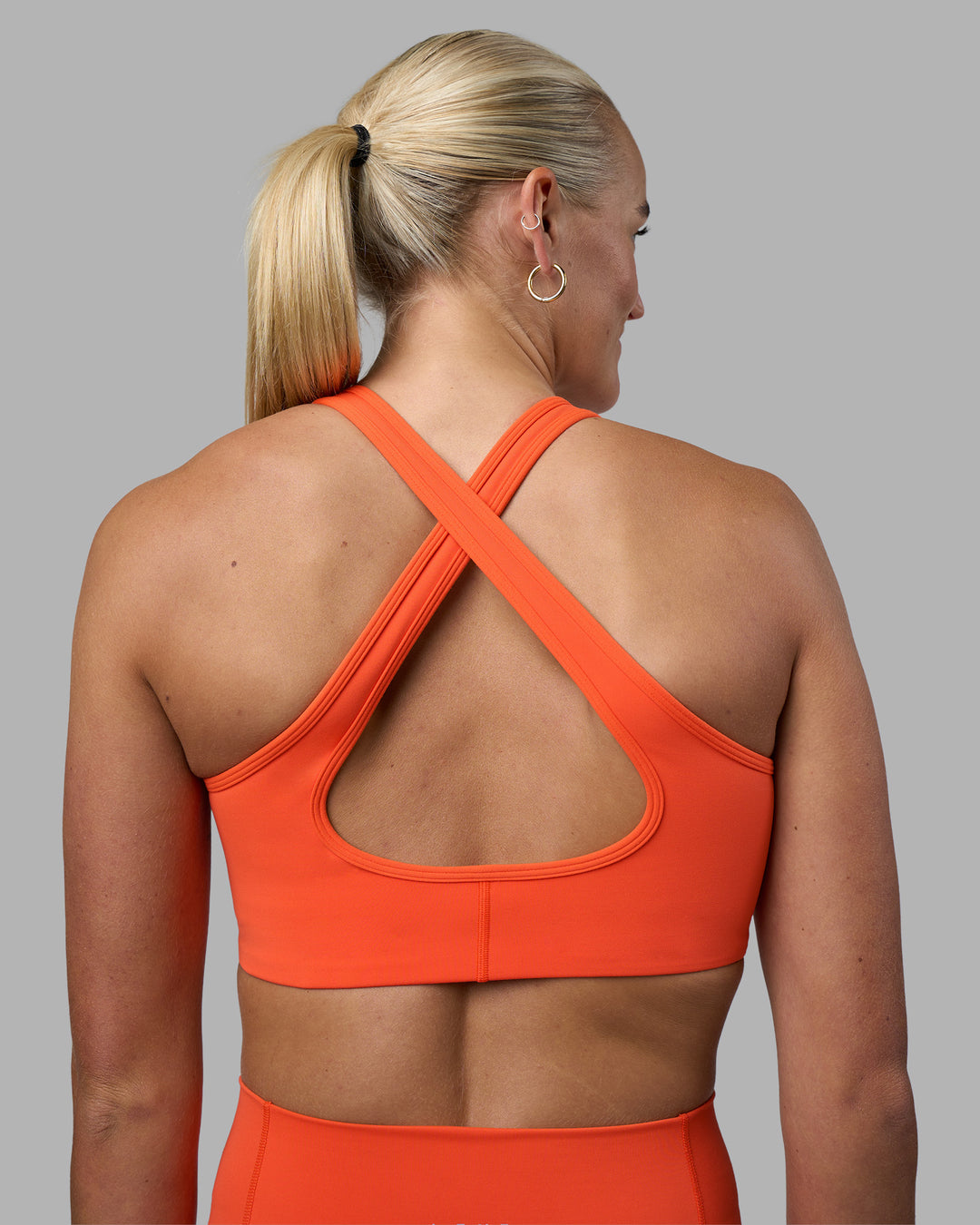 Woman wearing Stamina Sports Bra - Ultra Orange | Set:true | Angle:back | Model:Katie | Size:S - view 2