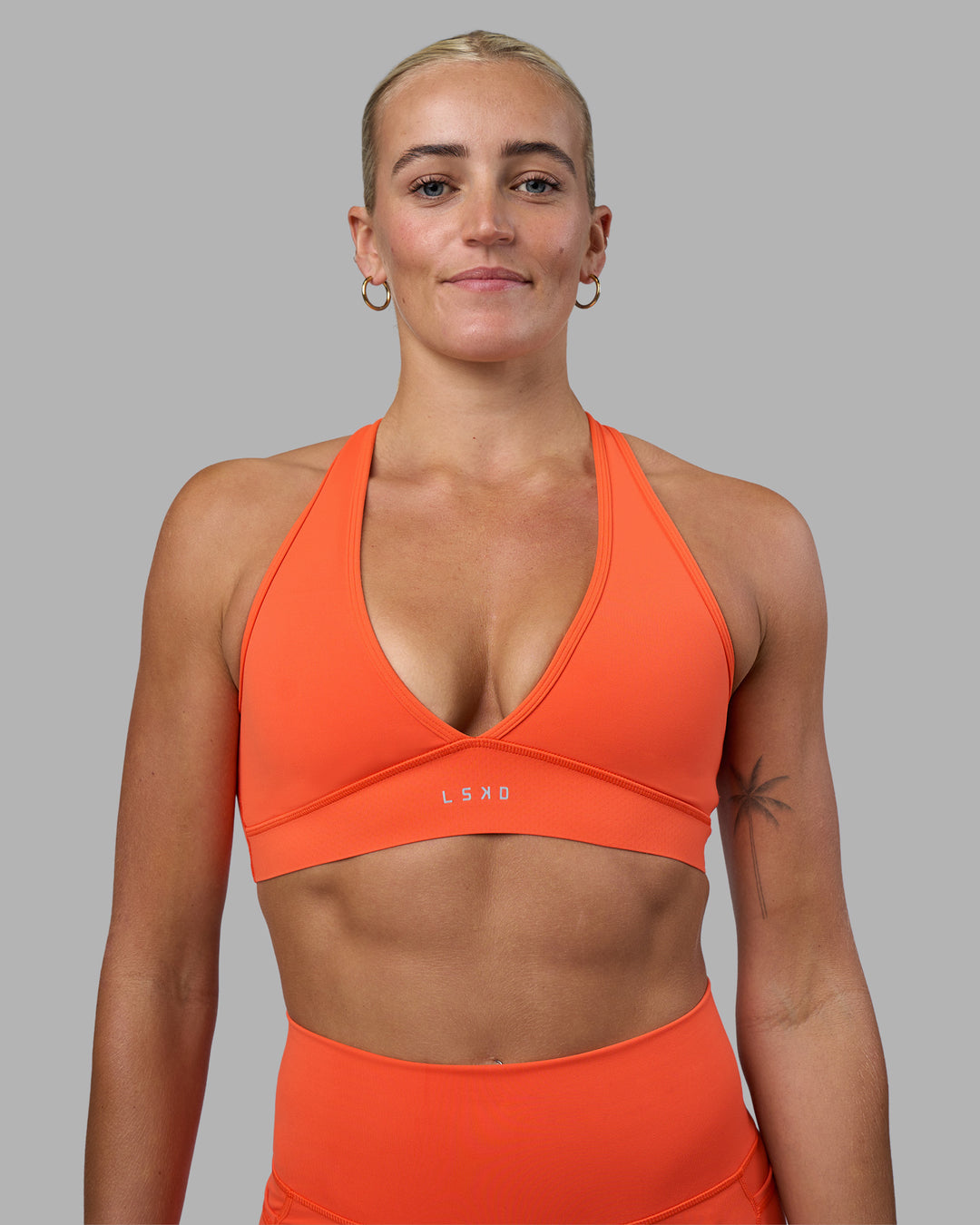 Woman wearing Stamina Sports Bra - Ultra Orange | Set:true | Angle:front | Model:Katie | Size:S - view 1