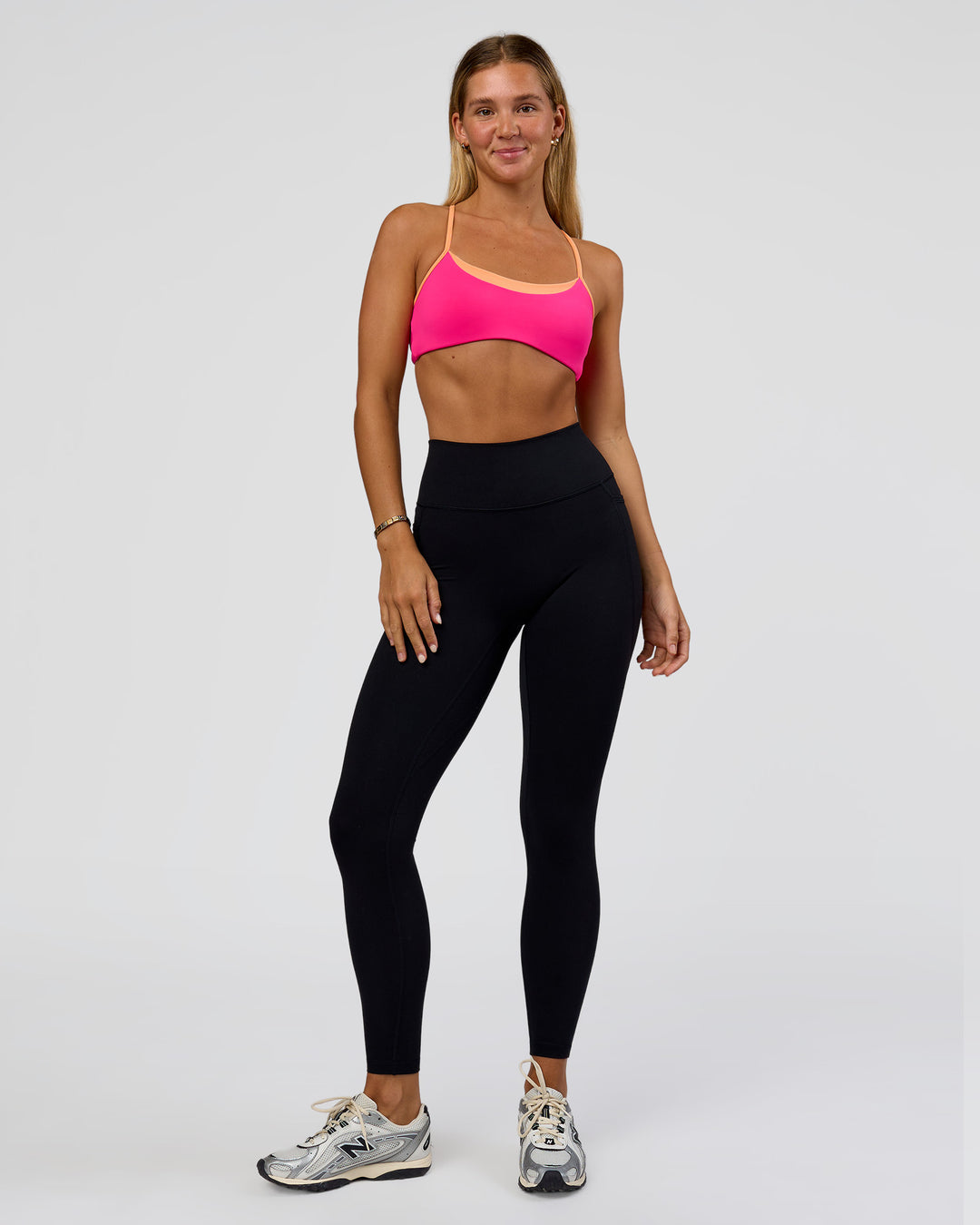 Woman wearing Tempo Sports Bra - Ultra Pink-Cantaloupe | Model:Amity | Size:S - view 5