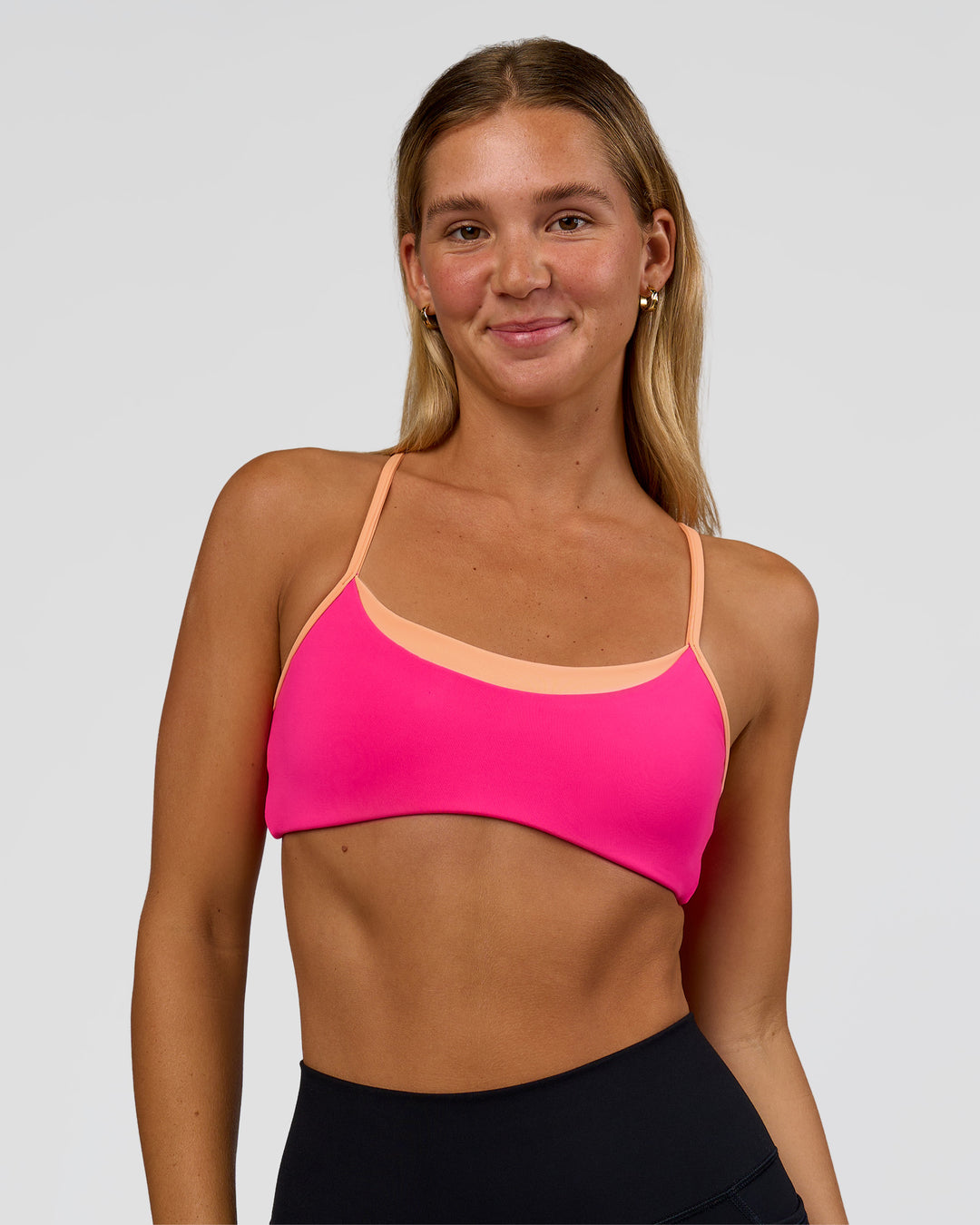 Woman wearing Tempo Sports Bra - Ultra Pink-Cantaloupe | Model:Amity | Size:S - view 1