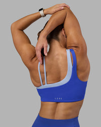 Woman wearing Thrive Asymmetric Sports Bra - Power Cobalt-Open Air | Model:Hannah | Size:S | Thumbnail Index: 0